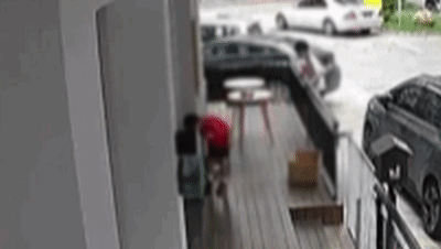 Ueberwachungs-GIF vor einer Tierhandlung, auf dem Jungen sich einem Katzenkaefig naehern