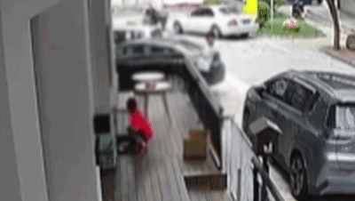 Ueberwachungs-GIF zeigt, wie der Junge in Rot den umzaeunten Bereich betritt und das Kaetzchen aufnimmt